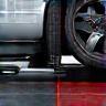 Technician performing tire alignment with digital equipment